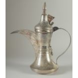 AN ISLAMIC SILVER EWER, with hinged cover and strapwork handle, curving spout, all with punched