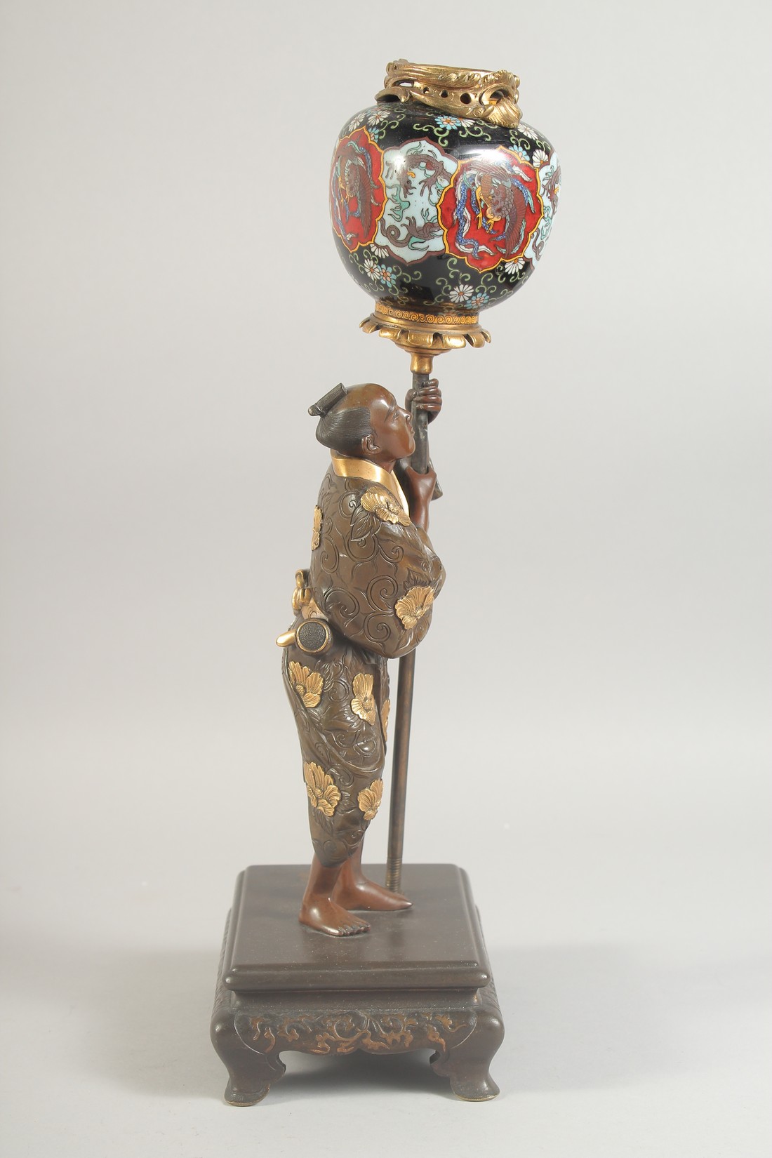 A FINE JAPANESE MEIJI PERIOD BRONZE OKIMONO holding a cloisonne urn aloft, the figure with gilt - Image 2 of 8