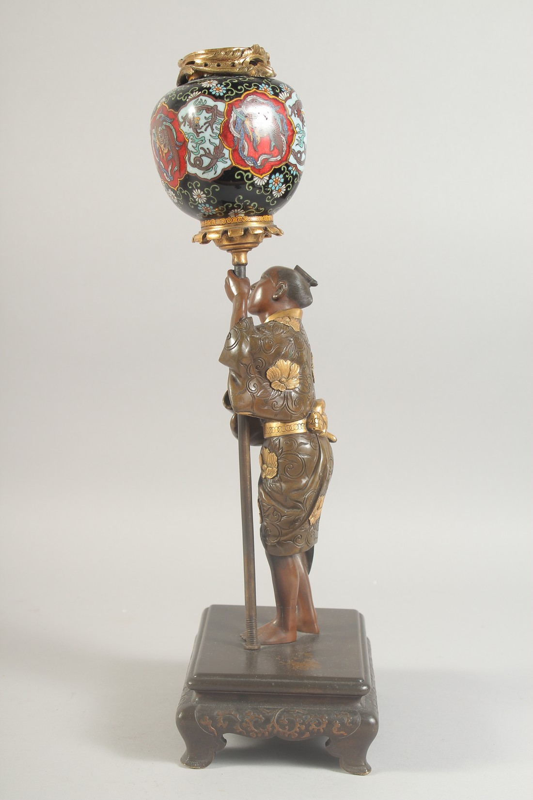 A FINE JAPANESE MEIJI PERIOD BRONZE OKIMONO holding a cloisonne urn aloft, the figure with gilt - Image 4 of 8