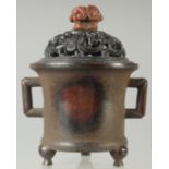A CHINESE QING DYNASTY BRONZE CENSER AND HARDWOOD COVER, with soapstone finial, 17cm high.