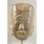 AN EARLY CARVED STONE HEAD, 11cm high.