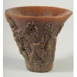 A GOOD CHINESE HORN LIBATION CUP carved with figures and foliage. 5.5ins high.