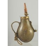 A RARE RHINO HORN POWDER FLASK with rope and brass fittings. 9.5ins long/