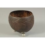 A CARVED COCONUT BOWL on ball feet.