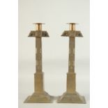 A PAIR OF, POSSIBLY AFRICAN, BRASS CANDLESTICKS. 15ins high.
