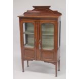 AN EDWARDIAN INLAID MAHOGANY BOW FRONT TWO DOOR DISPLAY CABINET with a gallery back, two fixed
