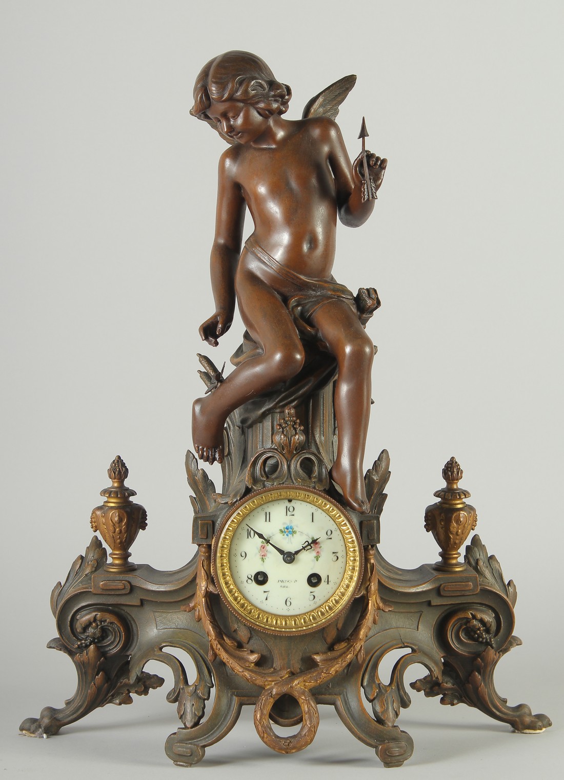 A 19TH CENTURY FRENCH SPELTER FIGURAL MANTLE CLOCK with eight day movement, floral painted porcelain