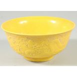 A CHINESE YELLOW GROUND CIRCULAR BOWL with dragons in relief. Mark in blue. 6ins diameter.
