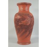 A LARGE CHINESE TERRA COTTA VASE carved with dragons and figures. 26ins high.