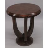 AN ART DECO STYLE ROSEWOOD CIRCULAR TABLE on curving supports. 2ft high x 1ft 9ins diameter.