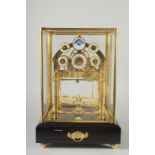 A GOOD MOON PHASE BRASS CONGREAVE CLOCK in a glass dome. 12ins high.