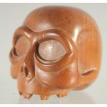 A WOODEN SKULL NETSUKE.