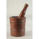 A GOOD EARLY 18TH CENTURY WOODEN PESTLE AND MORTAR. 8ins high x 7ins diameter.