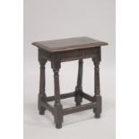 A 17TH CENTURY OAK JOINT STOOL with rectangular top, turned leg and a plain uniting stretchers.