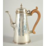 A PLAIN GEORGE II SILVER TAPERING COFFEE POT AND COVER with wooden handle. London 1737. Maker,