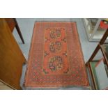 A Persian rug, red ground with three large motifs 167cm x 100cm.