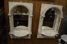 A pair of mirror backed painted wall shelves.
