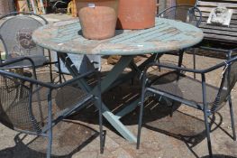 A painted wooden circular folding garden table.