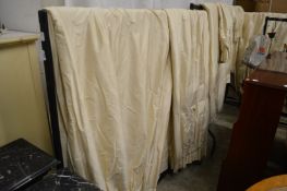 A quantity of cream silk curtains and pelmets.