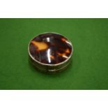 A silver and tortoiseshell circular patch box.