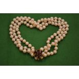 A three row pearl necklace with 9ct gold and gem set clasp.