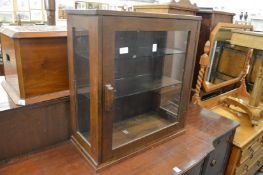 A small oak table top display cabinet.