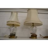 A pair of cut glass and brass table lamps (differing shades).