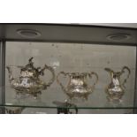 An early Victorian silver three piece tea service with embossed and chased decoration.