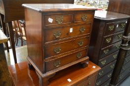 A small yew wood chest of drawers.