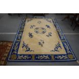 A Chinese carpet, cream ground within a blue border 270cm x 180cm.