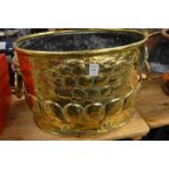 A good embossed brass coal or log bucket with lion mask handles.