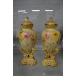 A pair of Worcester floral decorated blush ivory urn shaped vases and covers (small chips to