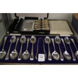 A cased set of twelve silver coffee spoons with matching sugar tongs and a cased set of silver