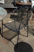 A set of four black painted wrought iron garden chairs.