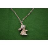 A cast silver pendant and chain.