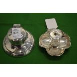 A small silver capstan inkwell and another inkwell.