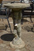 A composite bird bath modelled as a cherub holding aloft a circular dish.
