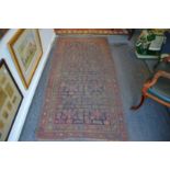 An old Persian rug, worn, 225cm x 110cm.