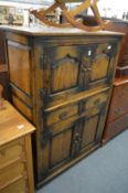 An 18th century style oak cupboard with four panel doors and two drawers.