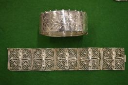 An engraved silver bangle and a filigree bracelet.