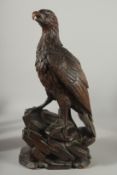 A LARGE HARDWOOD CARVING OF AN EAGLE ON A ROCKY OUTCROP; possibly Japanese, 40cm high.
