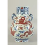 A CHINESE BLUE, WHITE AND UNDERGLAZE RED PORCELAIN TWIN HANDLE HU VASE, decorated with dragon and