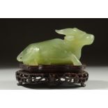 A CARVED JADE FIGURE OF A BULL on a fitted wooden stand, 11cm long.