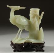 A CARVED JADE FIGURE OF A STORK on a fitted wooden stand, 15cm high overall.