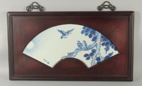 A CHINESE BLUE AND WHITE PORCELAIN PANEL, inset within a hardwood frame with fan shape border, the