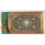 A PERSIAN METAL MOUNTED PAINTED WOODEN ALBUM, with central inset enamel panel painted with flora and