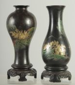 TWO BLACK AND GILT PAPIER MACHE VASES mounted to hardwood stands, 17.5cm high, (2).