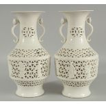 A PAIR OF CHINESE OPENWORK PORCELAIN VASES, each with moulded ruyi scepter twin handles, 26.5cm