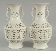 A PAIR OF CHINESE OPENWORK PORCELAIN VASES, each with moulded ruyi scepter twin handles, 26.5cm