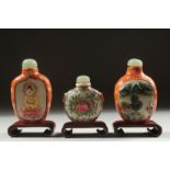 THREE CHINESE SNUFF BOTTLES AND STOPPERS with wooden stands, (3).